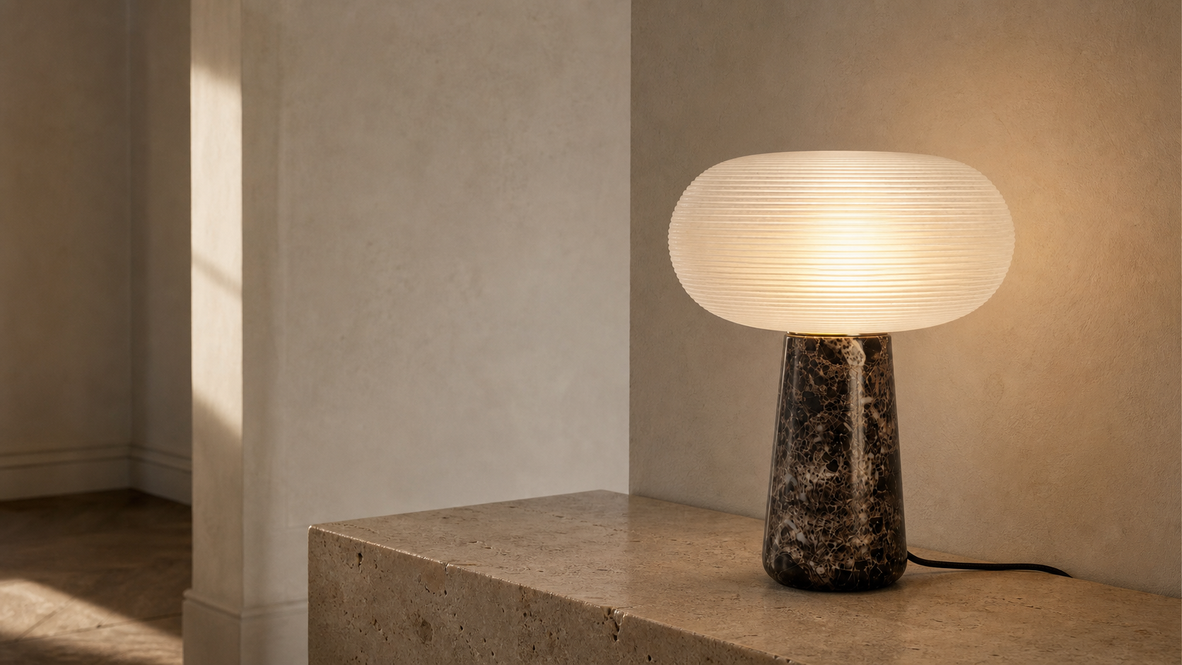 Lampe Brioche Maison Moya allumée sur une console en travertin
